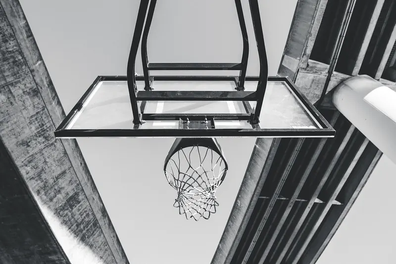 Basketballkorb mit Netz aus der Untersicht vor einer Betondecke