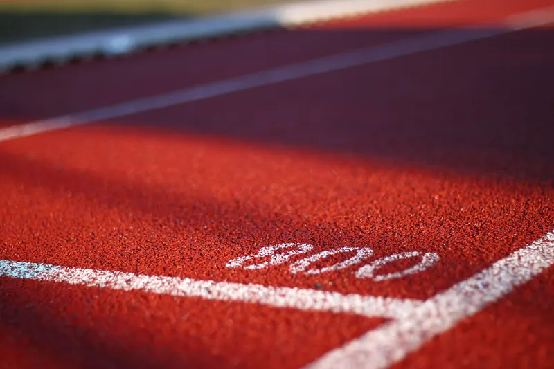 Rote Tartanbahn mit weißer Markierung der 800-Meter-Startlinie