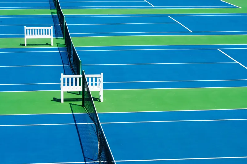 Blaue und grüne Tennisplätze mit Netz aus erhöhter Perspektive